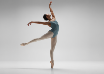 Adult ballet dancer performing an elegant pose in a bright studio, representing adult ballet classes in Toronto